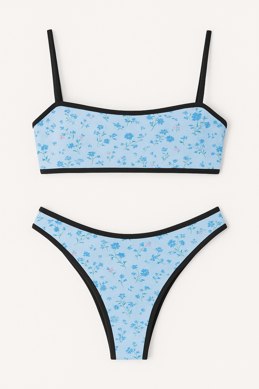 Light blue floral bikini set with black trim, featuring a bandeau top with adjustable straps and matching high-cut bottoms, ideal for summer beachwear, displayed on a plain white background for SISTER NY