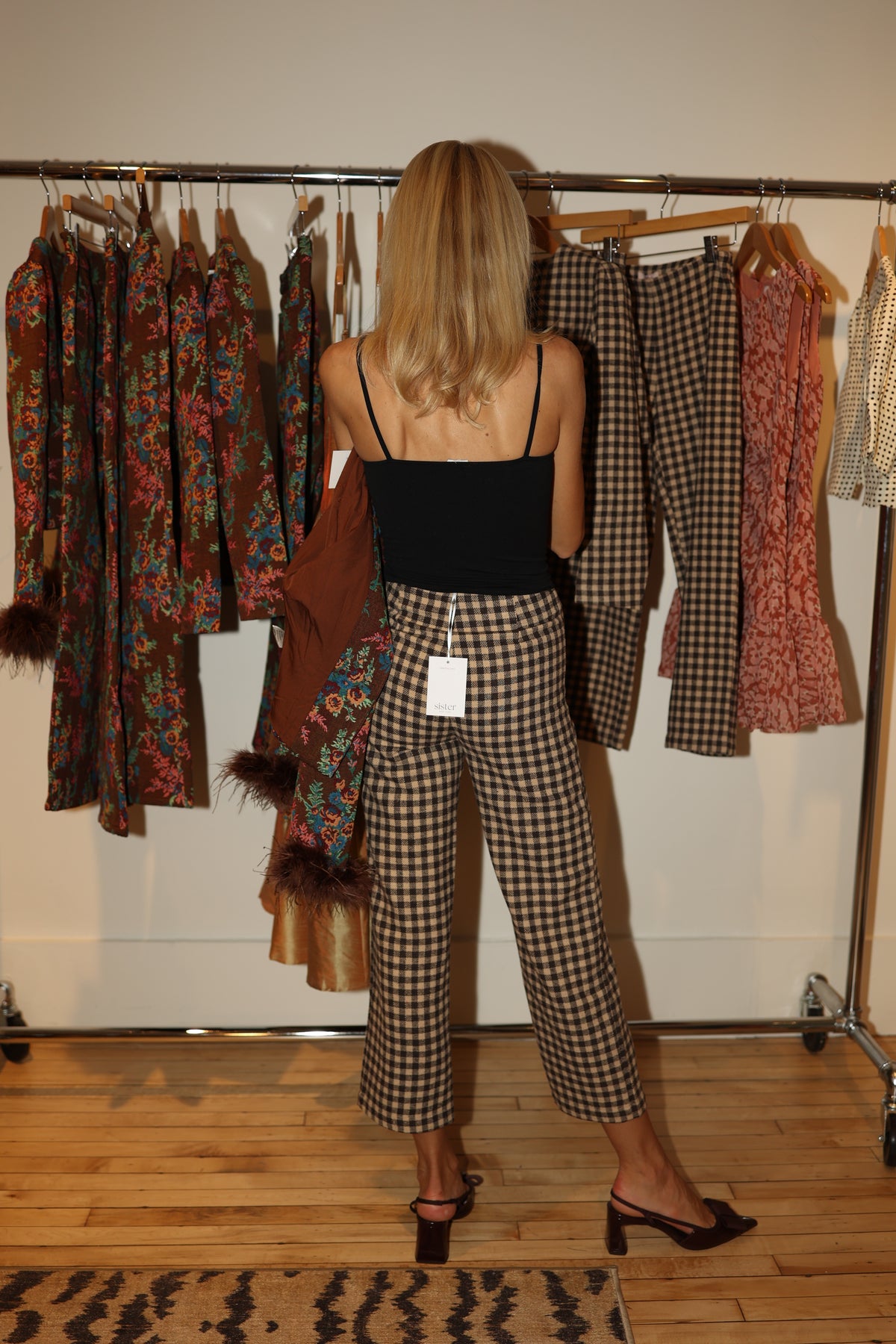 Woman selecting Sister NY checked pants from a clothing rack