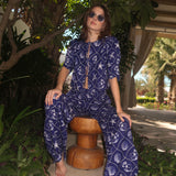 Woman modeling a blue printed linen set with matching top and pants in an outdoor setting.