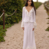 Model wearing a white linen lace tie-front top with matching maxi skirt, styled for a romantic coastal summer look by Sister New York